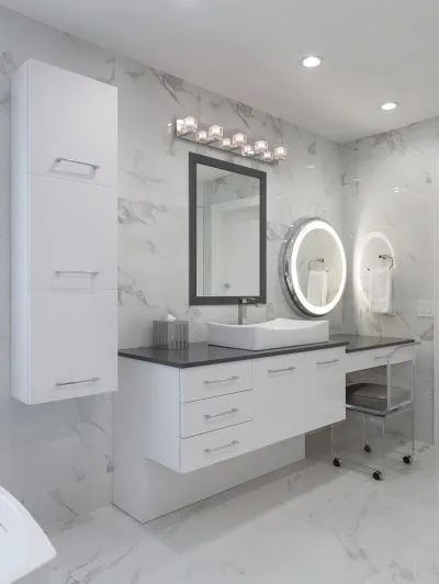 Modern white bathroom with double sinks, mirrors, and bright vanity lighting.