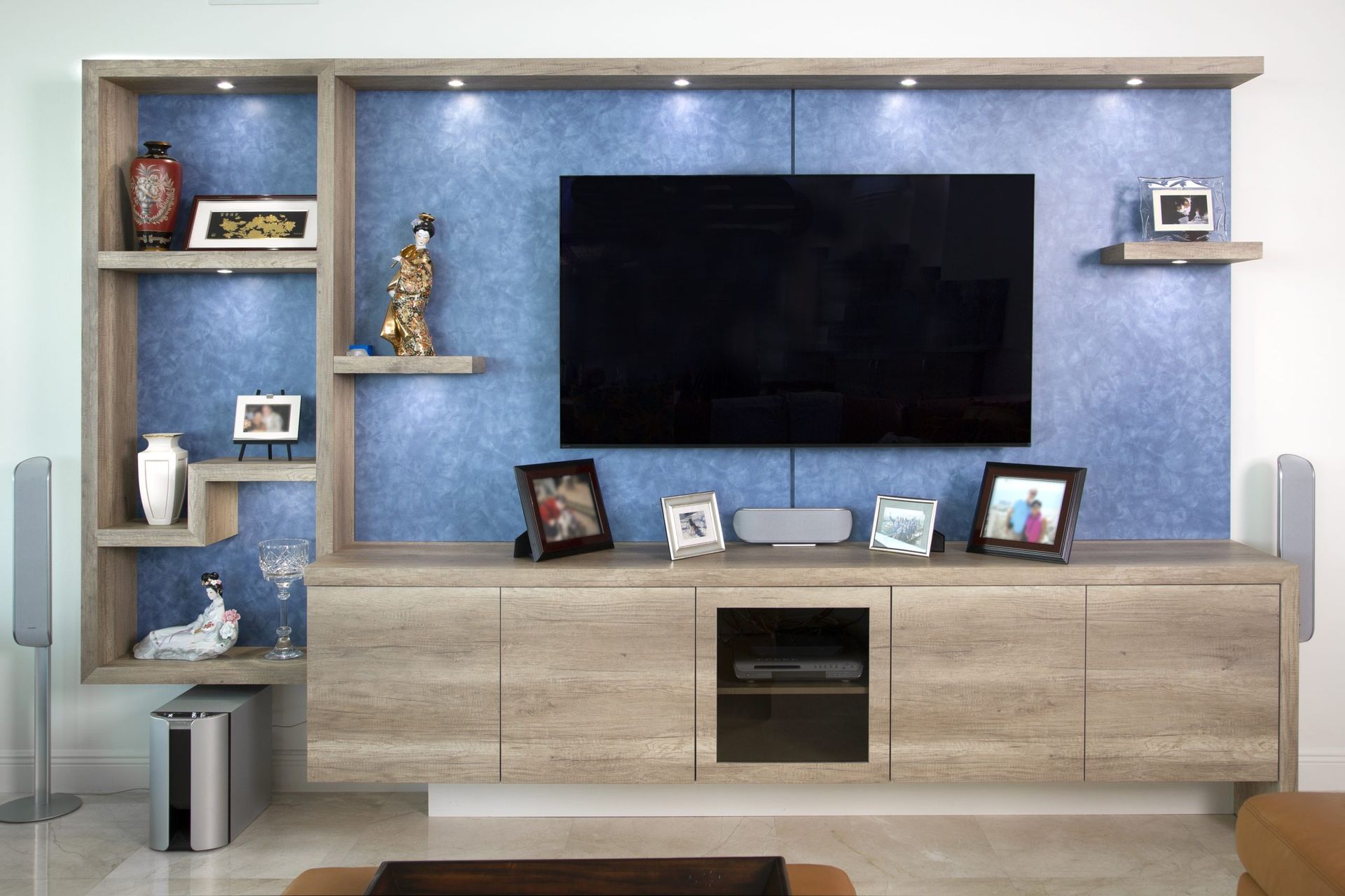 Modern TV wall unit with shelves, cabinets, and decorative items in a living room