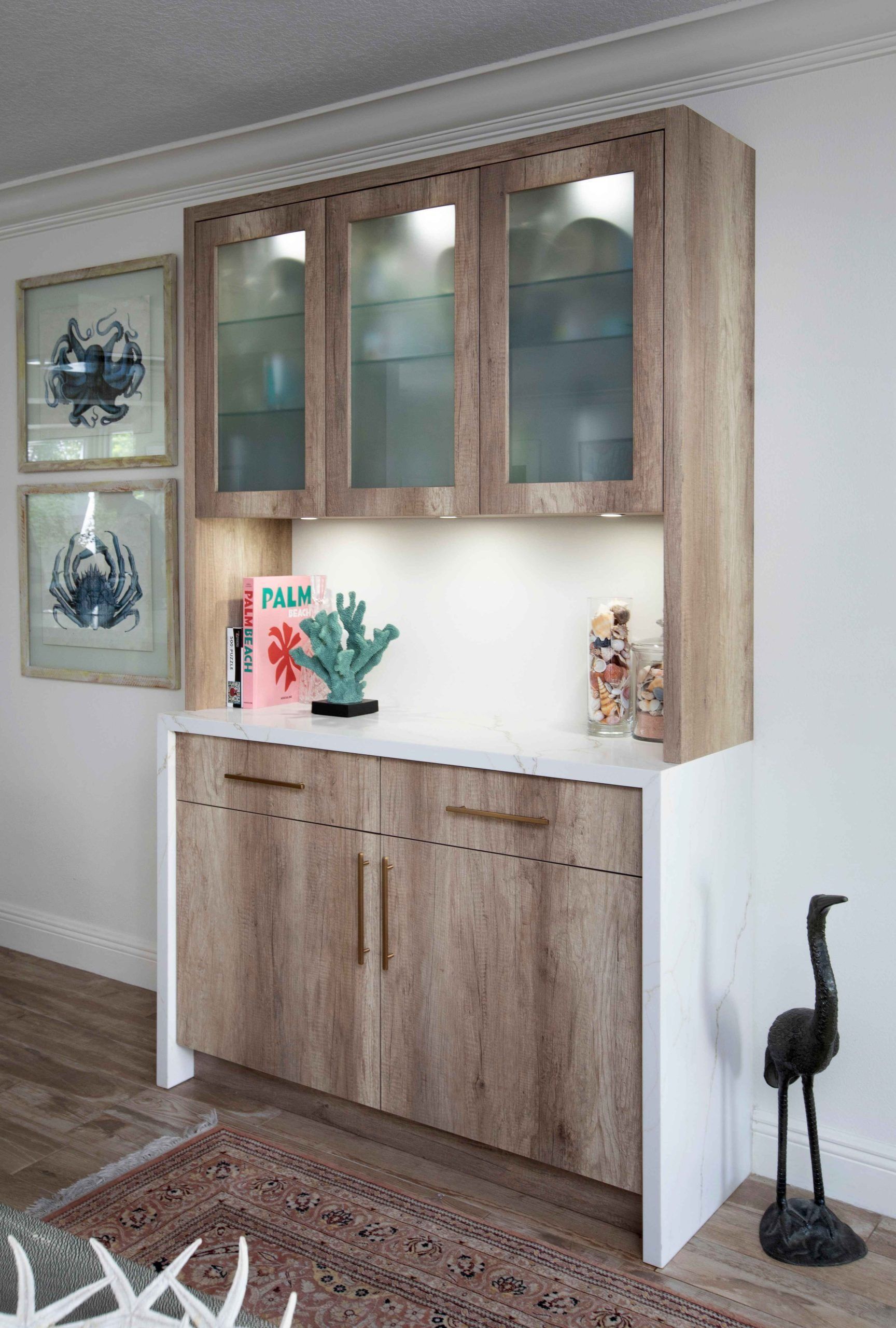 Built-in wooden cabinet with frosted glass doors and a white countertop in a living room.
