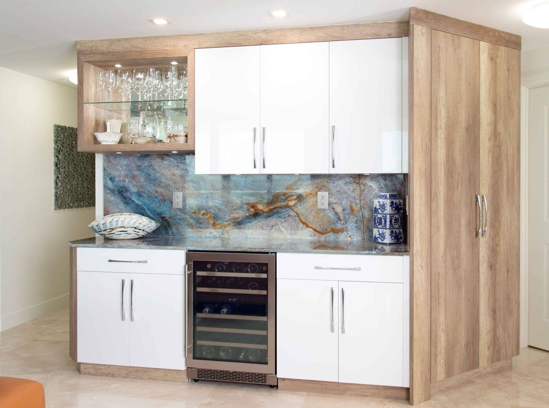 Modern kitchen with white cabinets, wood accents, a wine cooler, and a blue mosaic backsplash