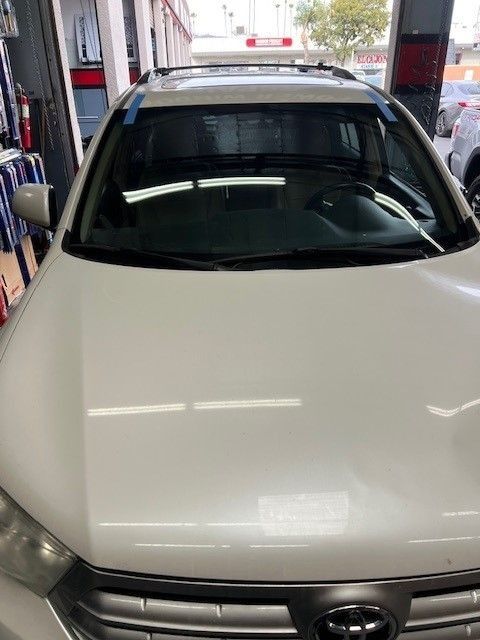 White Toyota Highlander with new windshield in repair shop.