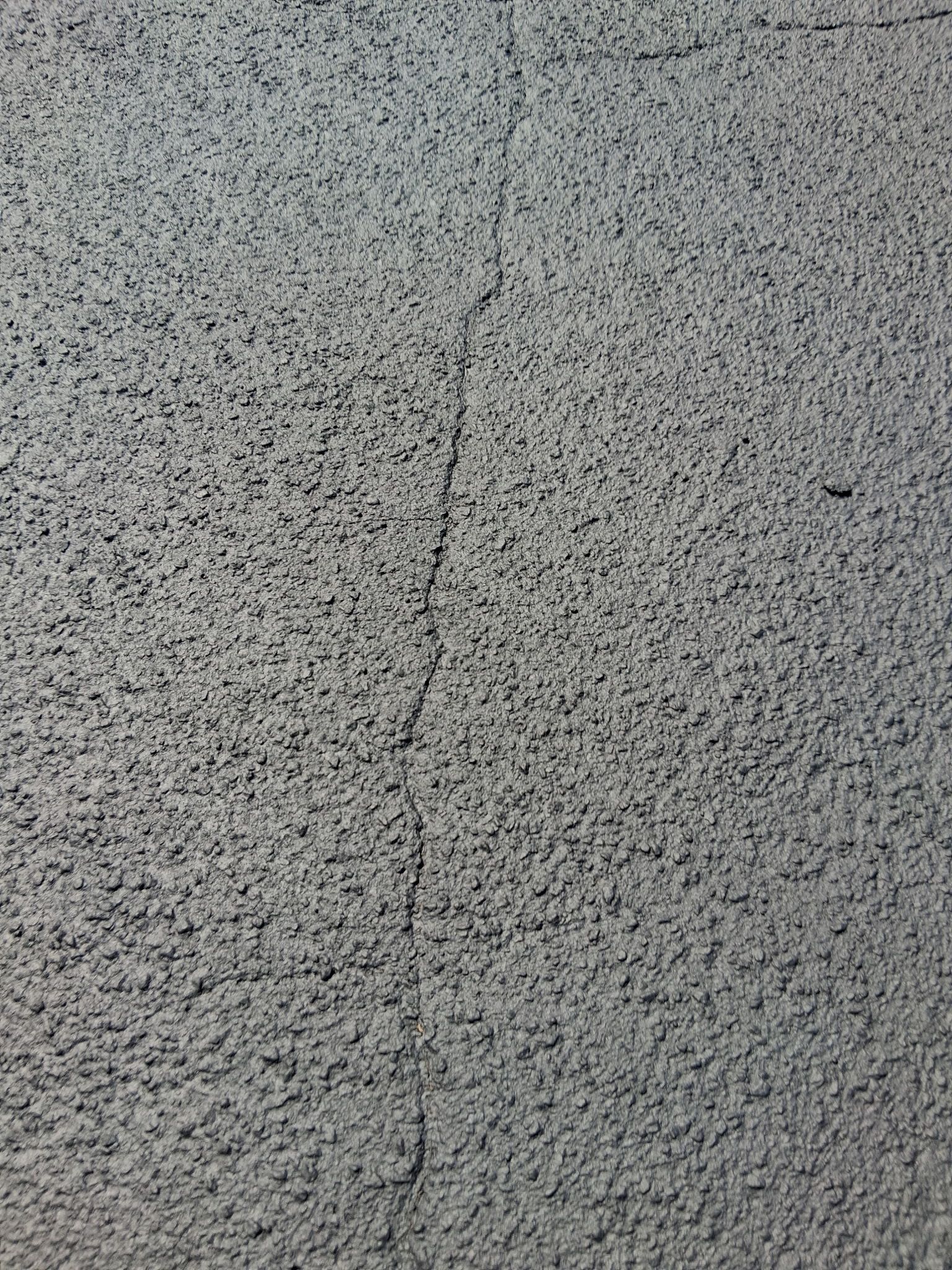 Gray textured wall with a vertical crack.