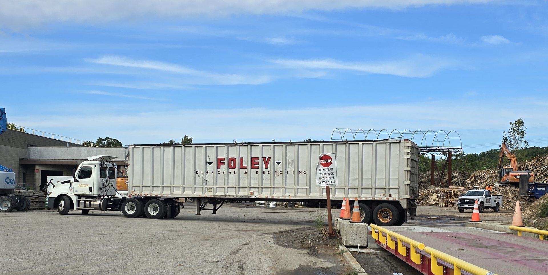 A white truck with the word poley on the side is parked in a parking lot.