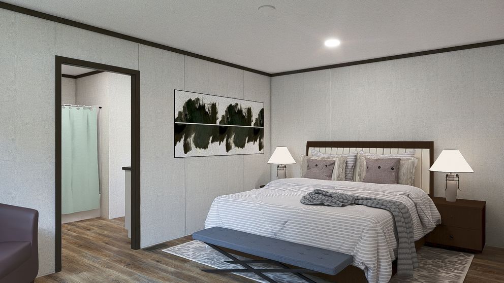 Modern bedroom with bed, bedside lamps, wall art, and an open doorway to a bathroom