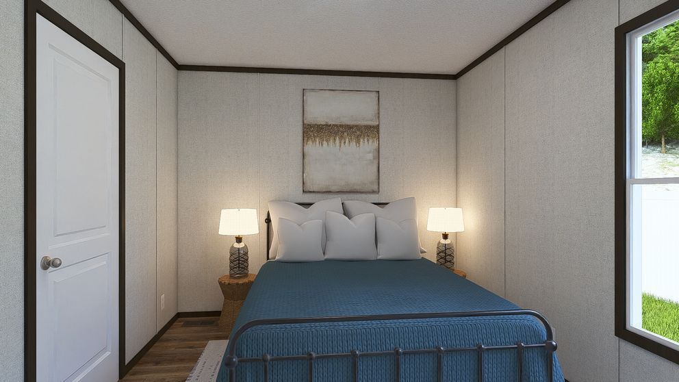 Small bedroom with a bed, two bedside lamps, white walls, and a window letting in daylight.