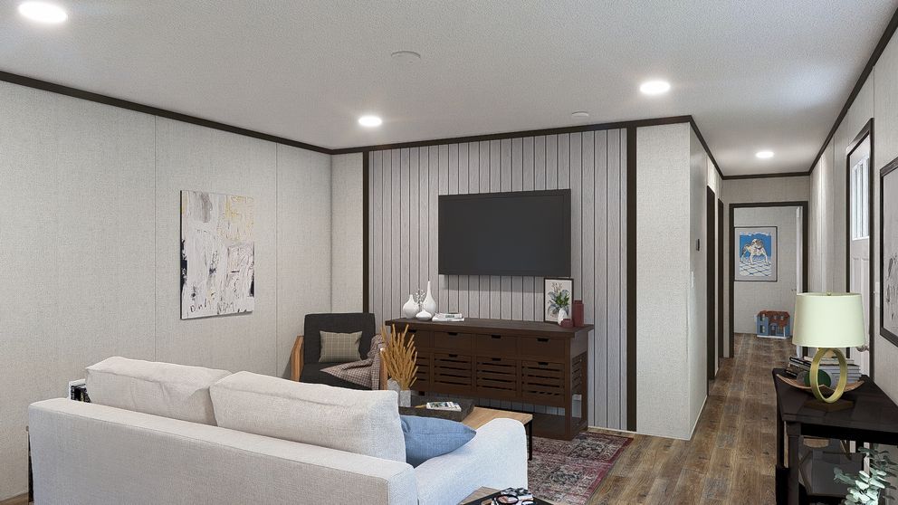 Modern living room with white sofa, TV stand, chair, hallway, and patterned rug