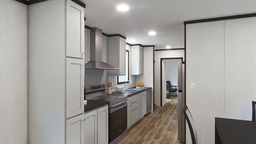 Modern kitchen with white cabinets, gray counters, and wood flooring, viewed from a hallway