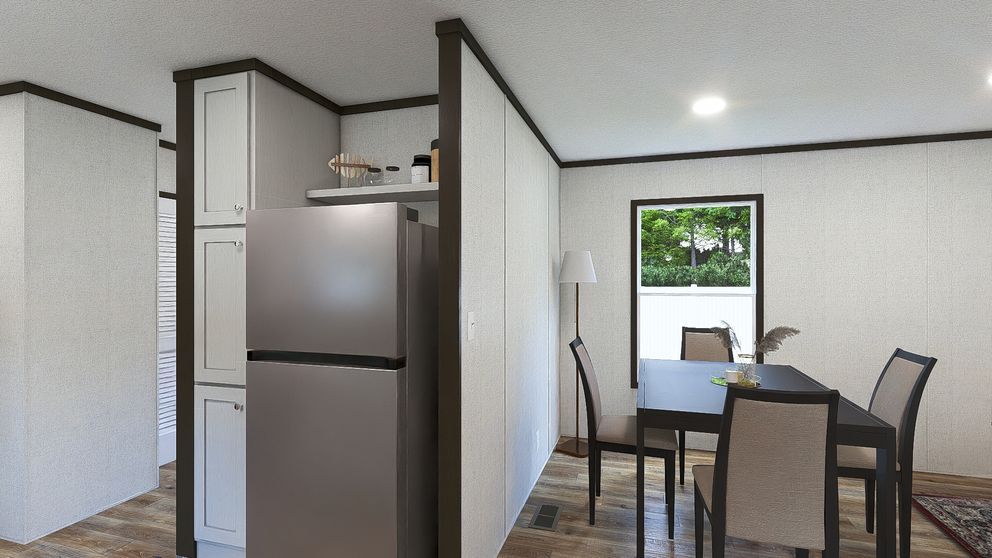 Small kitchen and dining area with stainless fridge, table, chairs, and a window overlooking greenery