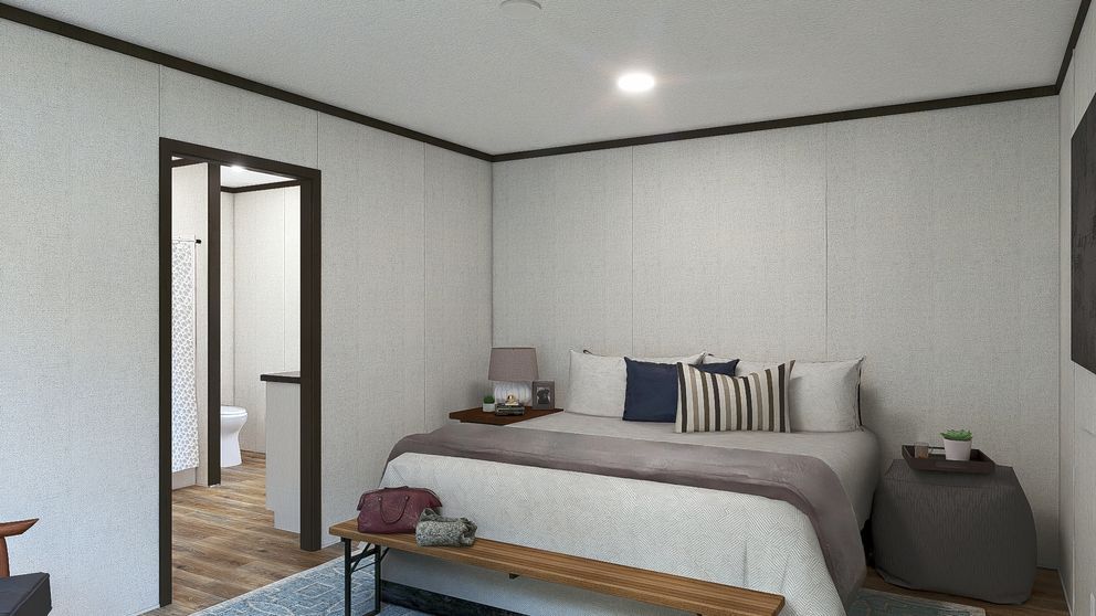 Minimalist bedroom with a neatly made bed, gray walls, and an open doorway to a hallway.