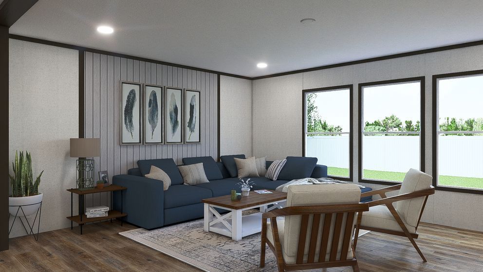 Modern living room with blue sofa, wooden chairs, coffee table, wall art, and large windows with a lake view