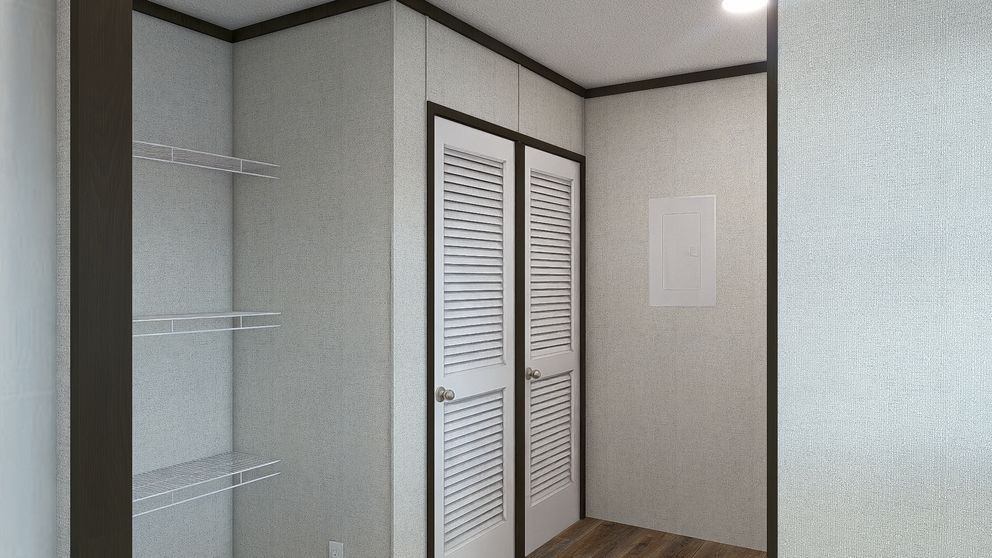 Empty bedroom closet area with white louvered doors, glass shelves, and beige walls