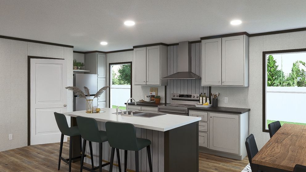 Modern kitchen with white cabinets, gray island, black bar stools, and large windows