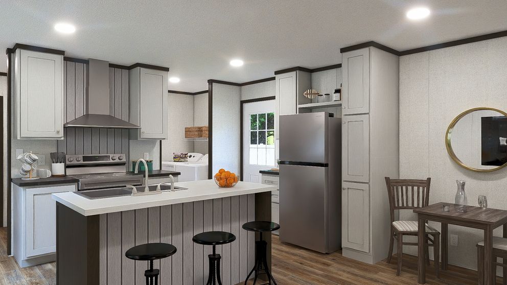 Modern gray kitchen with island, stainless fridge, stools, and a small dining nook by a round mirror
