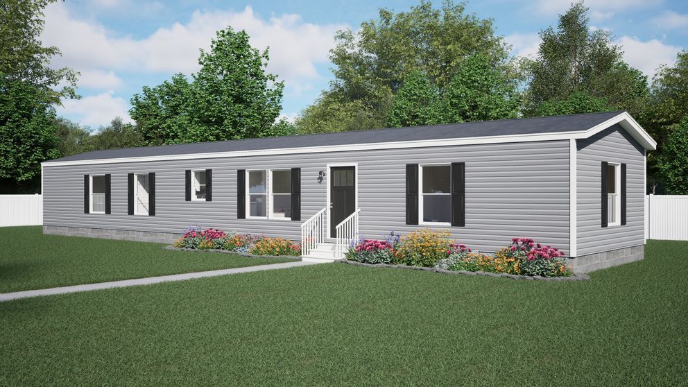 Single-story gray house with black shutters, flower beds, and a green lawn under a partly cloudy sky