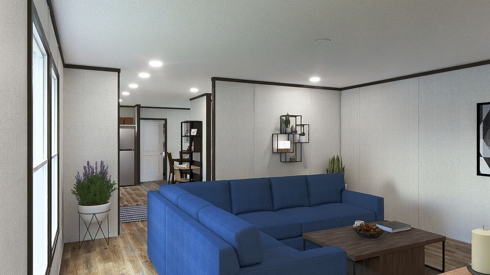 Modern living room with a blue sectional sofa, wood coffee table, and white walls with black trim.