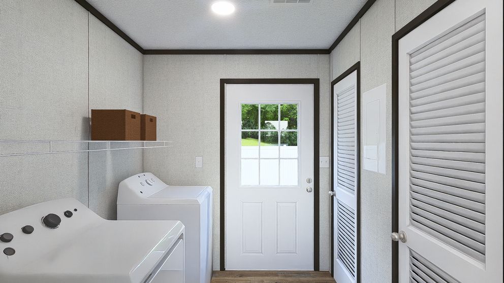 Small laundry room with washer, sink, and white louvered doors near a back door.