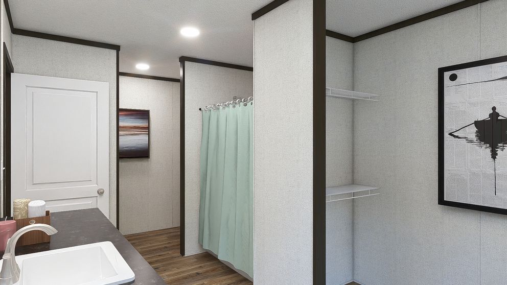 Modern bathroom with sink, shower curtain, and framed wall art; wood floor and white walls.