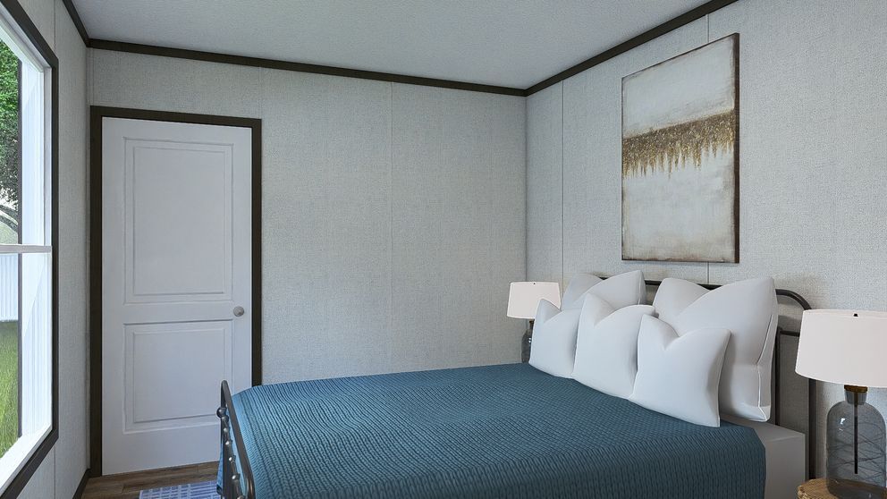 Bright bedroom with blue bedspread, white pillows, bedside lamps, and framed wall art.