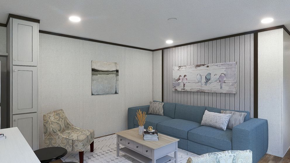 Modern living room with blue sectional sofa, patterned armchair, coffee table, and striped accent wall
