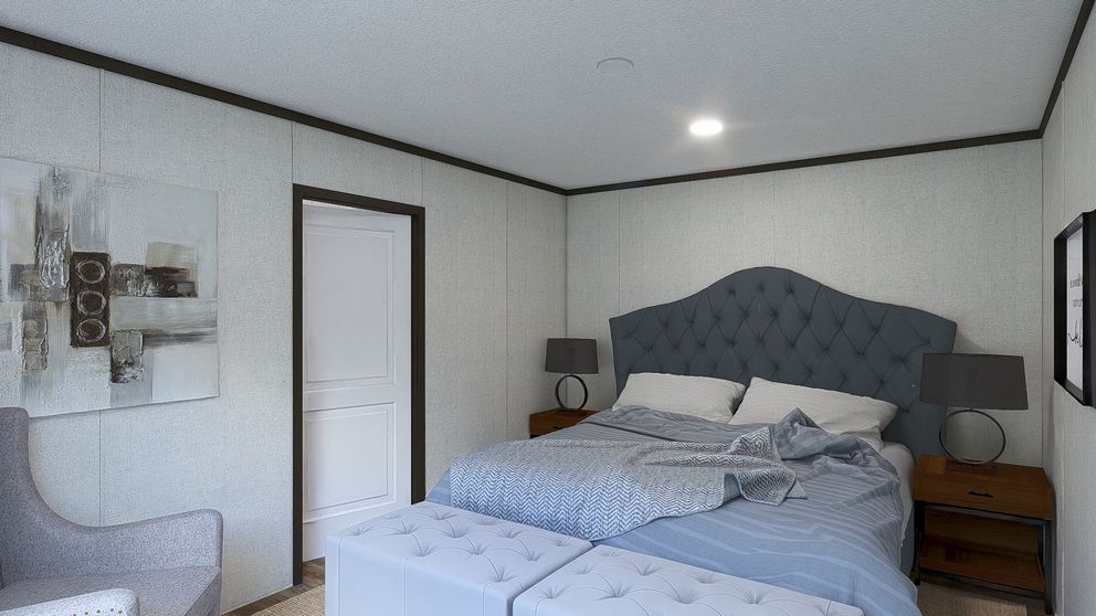 Bright bedroom with a blue upholstered bed, white walls, and a nightstand lamp.