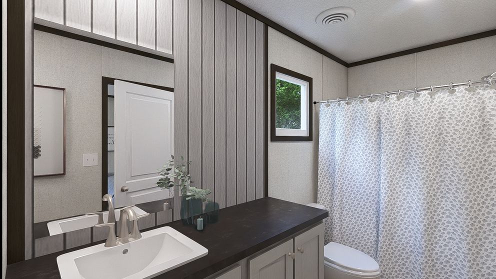 Modern bathroom with sink, mirror, dark countertop, striped walls, and shower curtain
