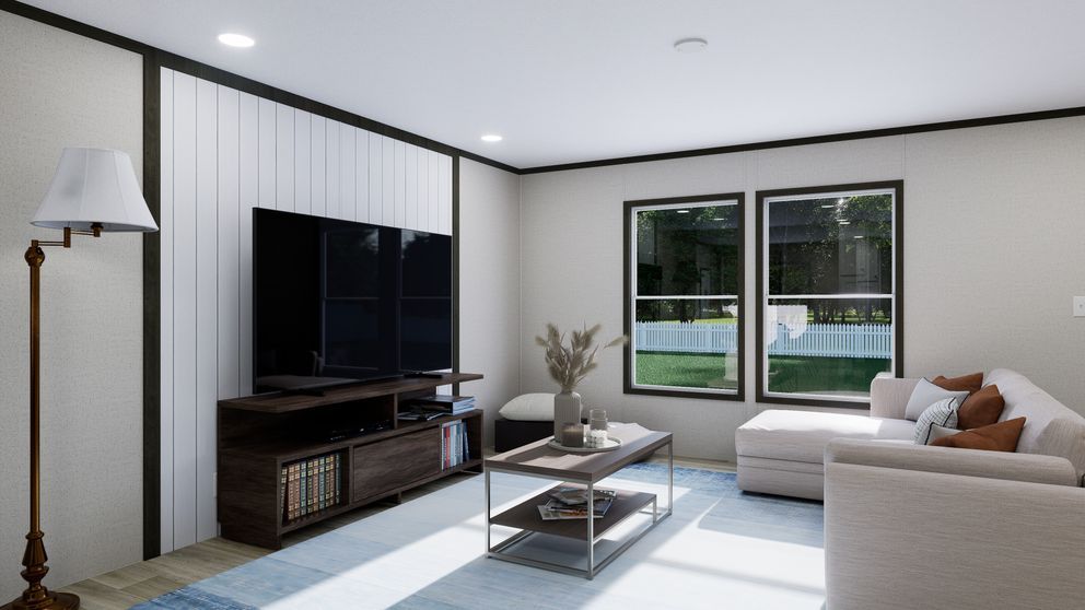 Bright modern living room with white sofa, TV console, coffee table, and large window view