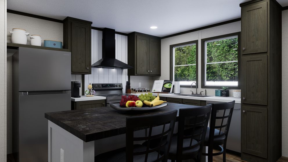 Modern kitchen with dark cabinets, stainless fridge, island, and fruit bowl by a bright window