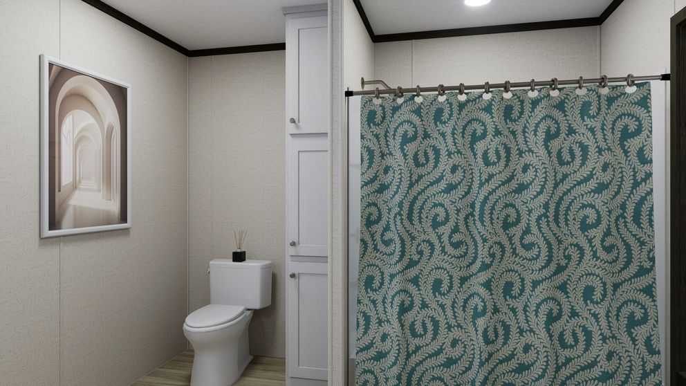 Small bathroom with white toilet, framed wall art, and teal patterned shower curtain.
