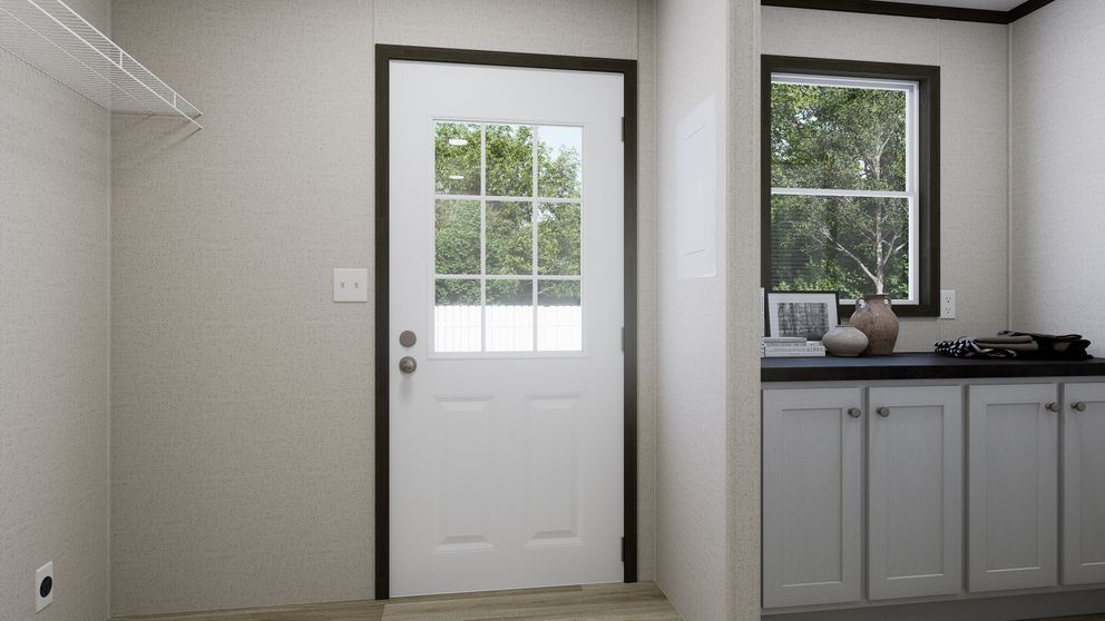 Interior doorway with a white door, window view, and kitchen counter cabinets on the right.
