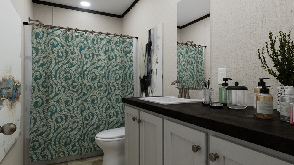 Modern bathroom with green patterned shower curtain, black countertop, and white sink cabinet
