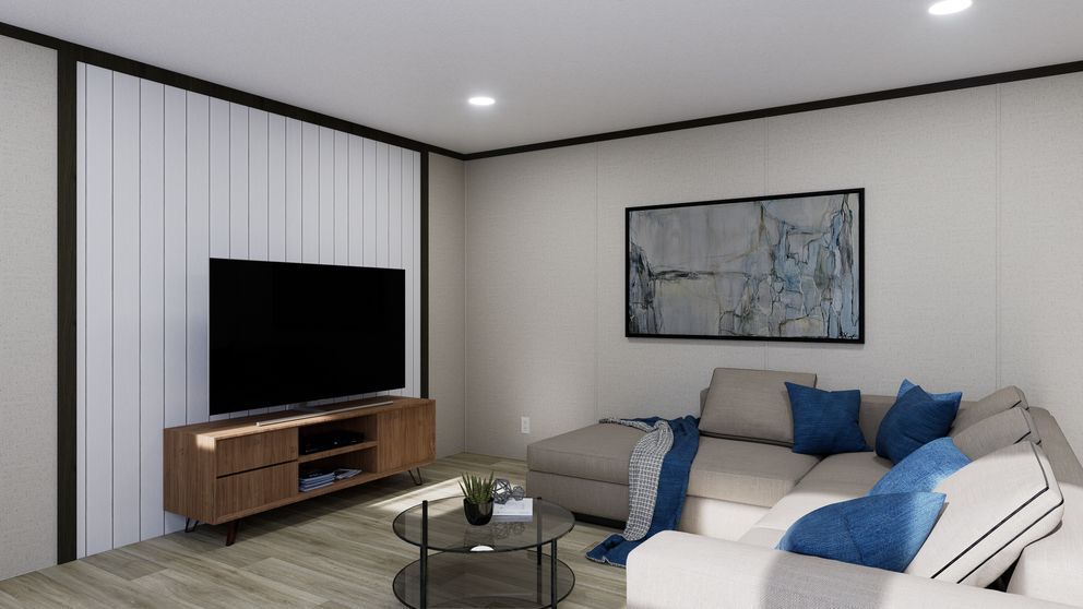 Modern living room with gray sectional, blue pillows, TV on wooden stand, and framed wall art.