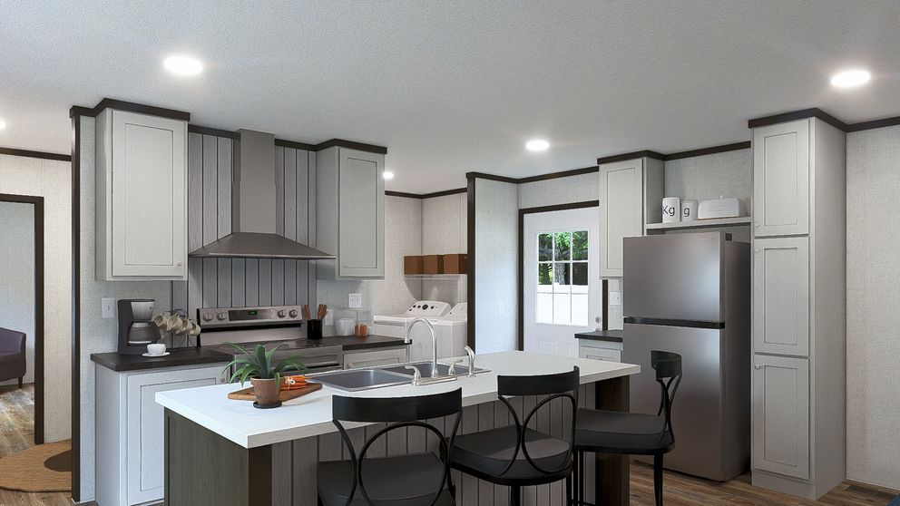 Modern kitchen with white cabinets, stainless appliances, large island, and black dining chairs by a window.