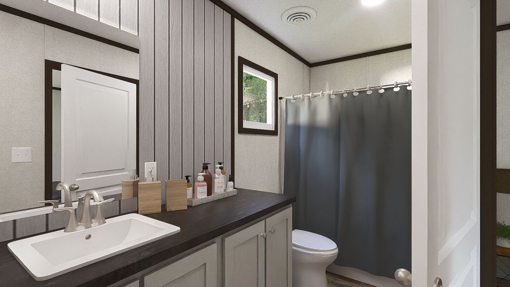 Modern bathroom with vanity sink, mirror, and gray shower curtain beside a toilet.