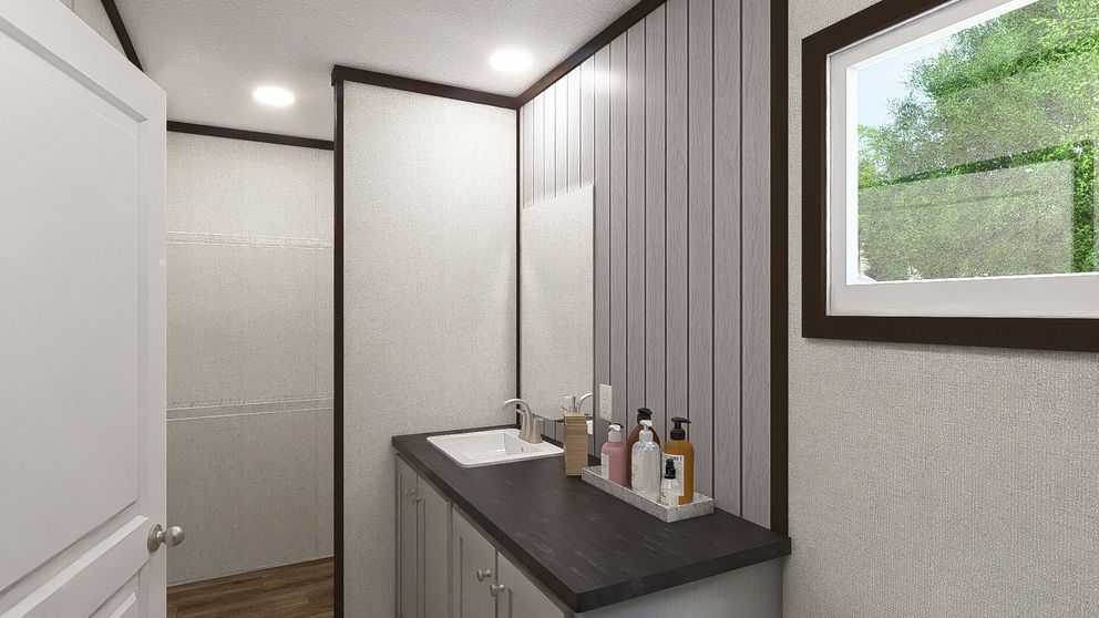 Modern bathroom interior with vanity, toiletries, and a window showing greenery