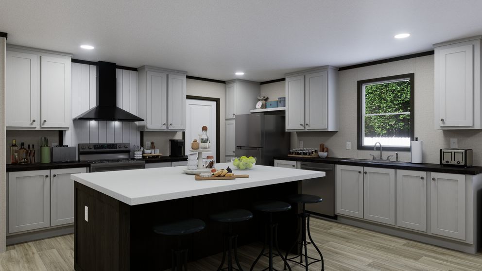 Modern kitchen with white cabinets, dark island, stainless appliances, and a window over the sink.