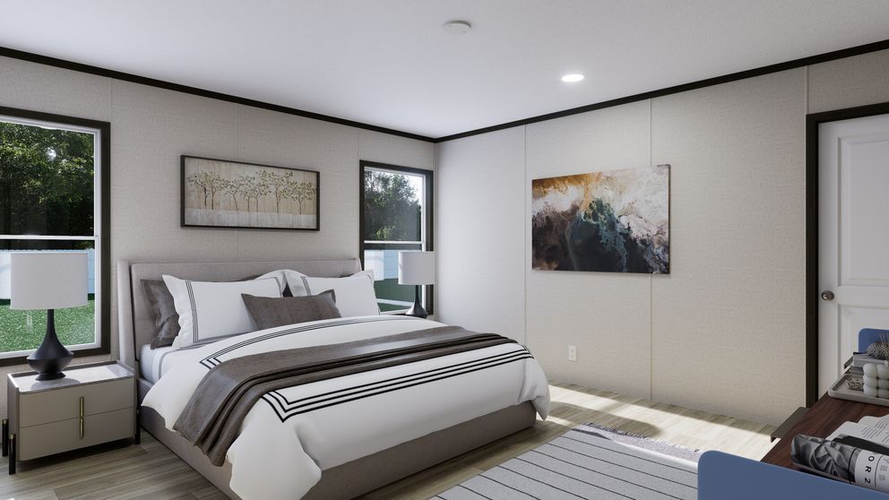 Modern bedroom with a large bed, gray walls, windows, and framed wall art.