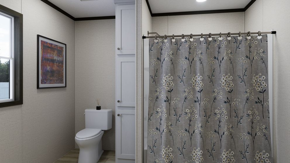 Small bathroom with a toilet, shower curtain, framed wall art, and a window.