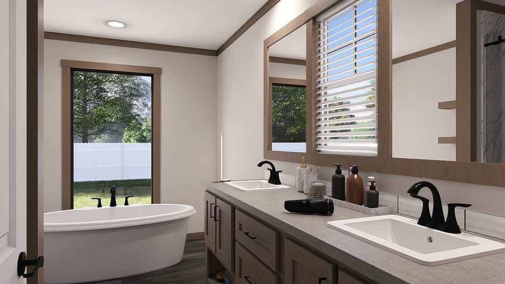 Bright modern bathroom with double vanity, large mirror, and a freestanding tub by a window.