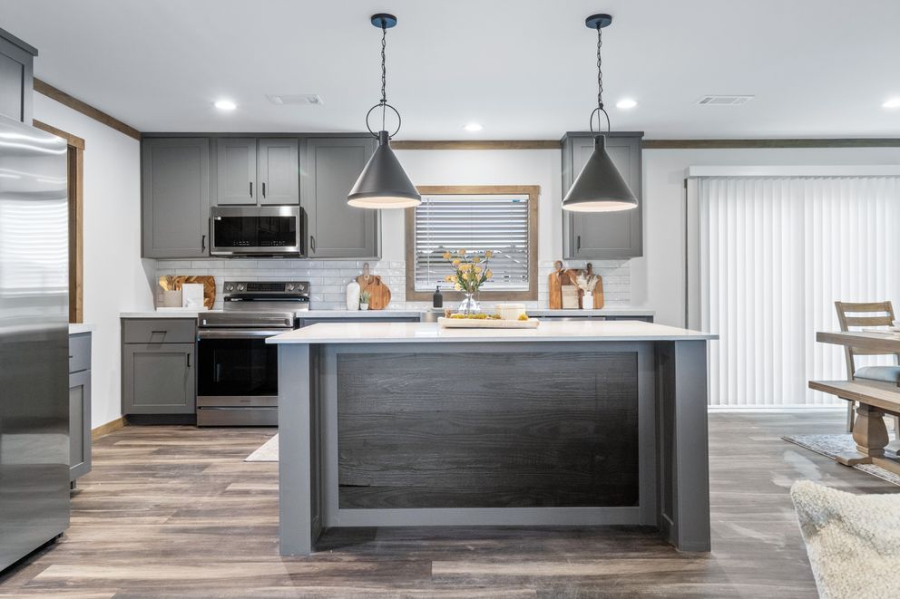 Modern kitchen with gray cabinets, center island, stainless appliances, and two pendant lights