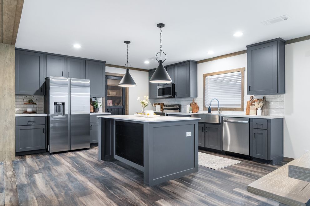Modern gray kitchen with central island, stainless steel appliances, pendant lights, and wood-look flooring