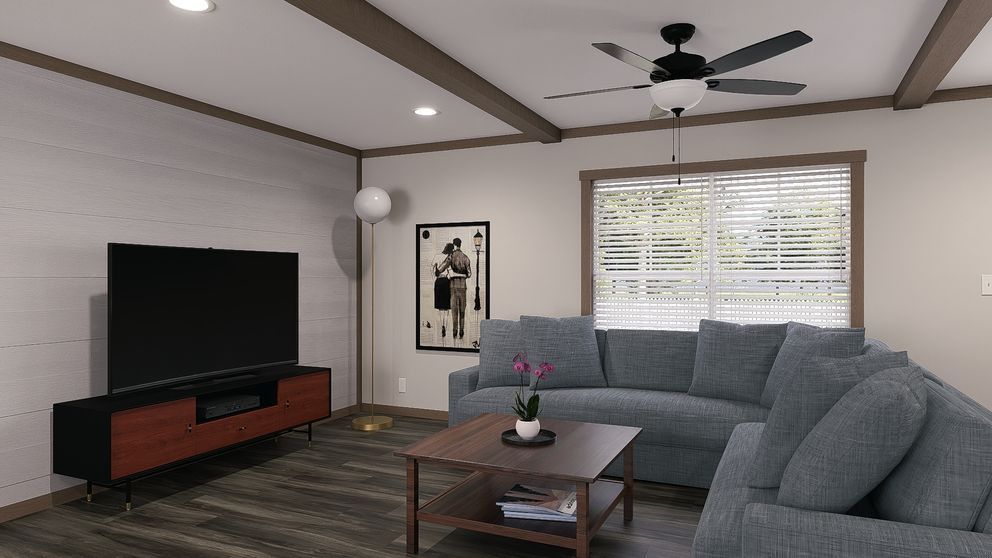 Modern living room with gray sectional, TV, coffee table, and ceiling fan