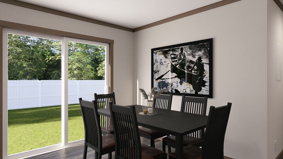 Dining room with a dark table and chairs beside a sliding glass door, showing a backyard and white fence.