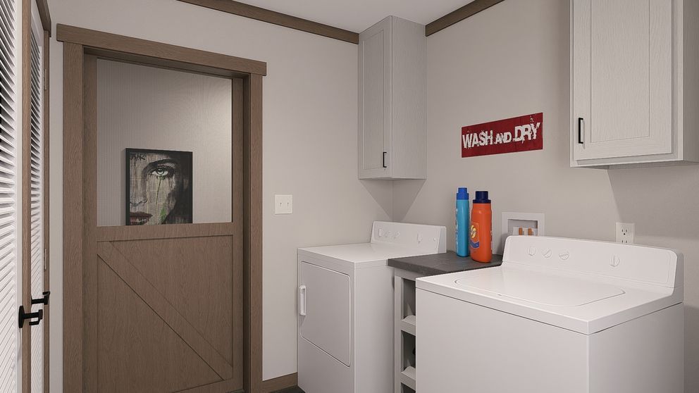 Laundry room with washer, dryer, utility sink, cabinets, and a partially open door.