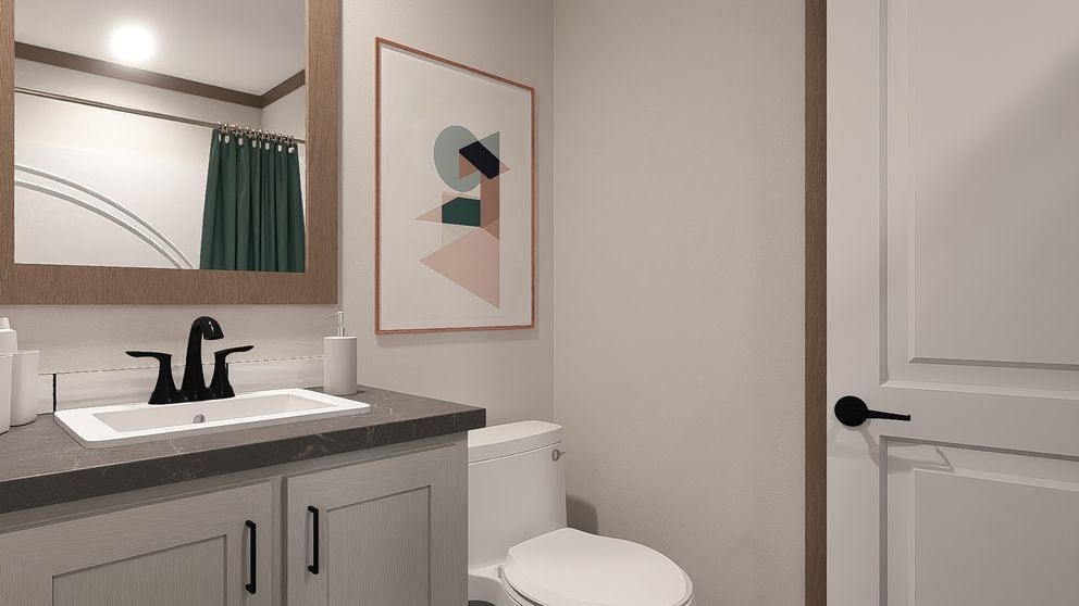 Modern bathroom with white vanity, black faucet, toilet, mirror, and framed wall art