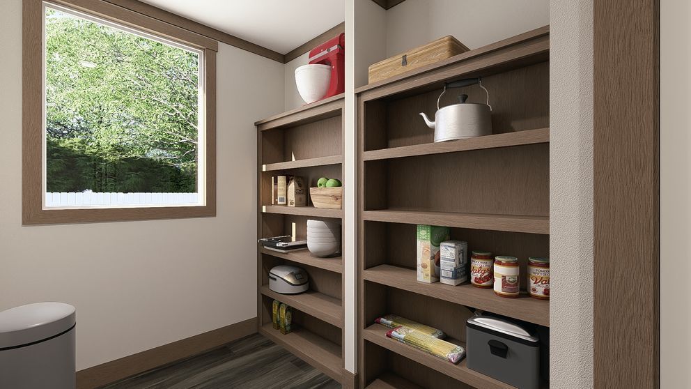 Small pantry with wooden shelves holding jars, cans, cookware, and baskets beside a window.