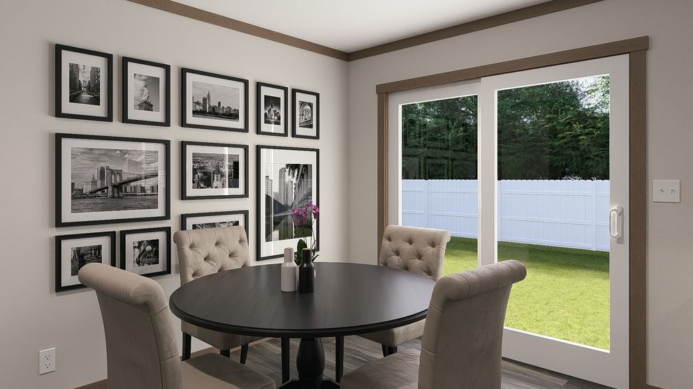 Dining nook with round black table, beige chairs, gallery wall, and sliding glass door to a backyard.