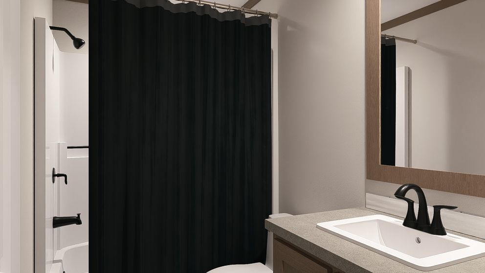 Bathroom vanity with sink and mirror, white walls, and a black shower curtain in the background