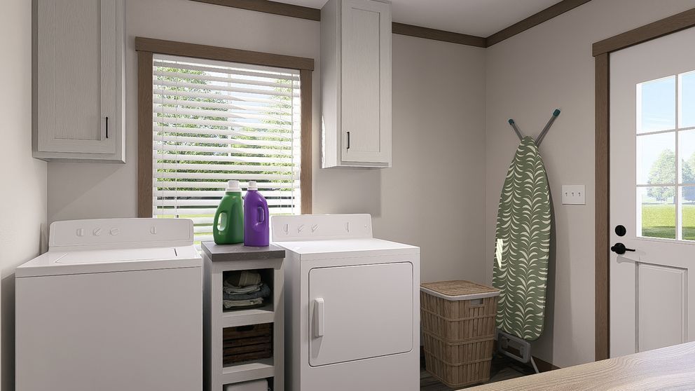 Laundry room with washer, dryer, folding station, window, and ironing board beside a basket.