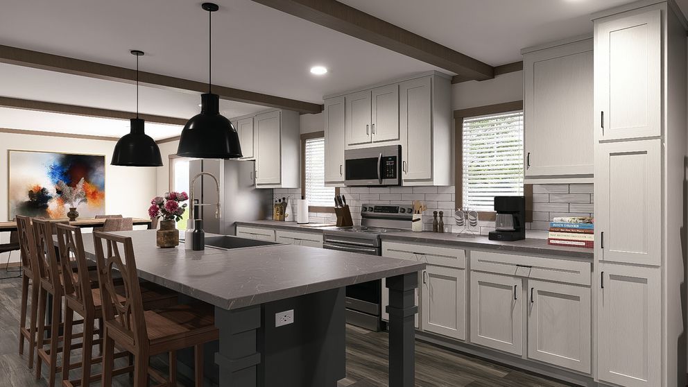 Modern kitchen with gray cabinets, large island, pendant lights, and a window over the sink