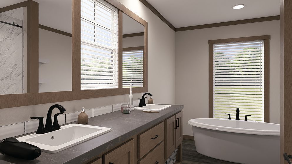 Modern bathroom with double sinks, large mirrors, and a freestanding tub by a window with blinds